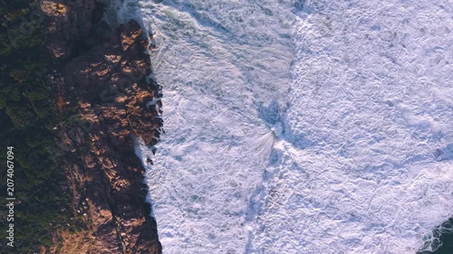 Aerial overhead waves breaking on the coastline