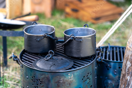 Canvastavla Metal cooking pots and stew pot lid on outdoor medieval campfire stove