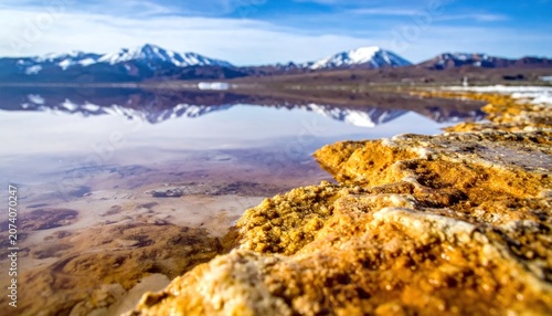 Orange rocks by calm lake water.