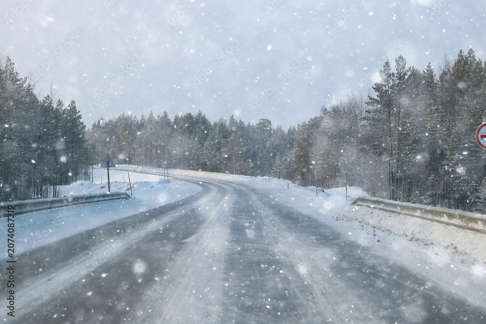 Fototapeta premium snowfall on a winter road, abstract background, blurred highway backdrop snowy landscape