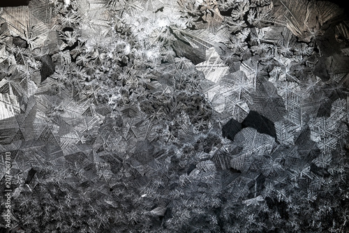 Tableau sur toile Ice crystals freezing on a black background, abstract winter photo surface