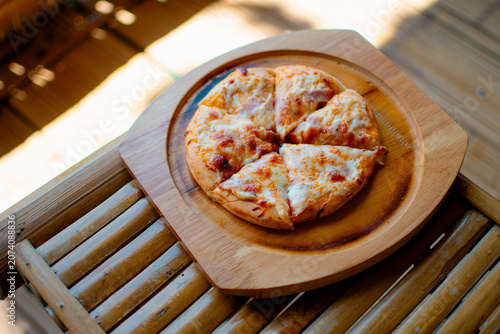 Pizza on a wooden tray, with a beautiful mountain view as a backdrop. 