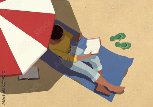 View from above young woman reading book and relaxing under striped umbrella on sunny summer beach