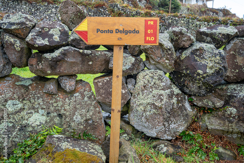 Pedestrian trail direction sign for Ponta Delgada, Flores Island, Azores. Pedestrian trail sign leading to the Poço do Bacalhau waterfall, Ilha das Flores, Azores, Portugal.
