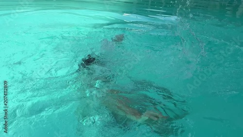 Video of a man swimming in a modern swimming pool. Healthy lifestyle and fitness concept representing physical activity, endurance, recreation and aquatic sports.