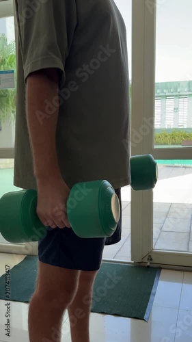 Video of a man performing dumbbell exercises in a modern gym. Fitness and strength training concept representing an active lifestyle, muscle building and personal health.