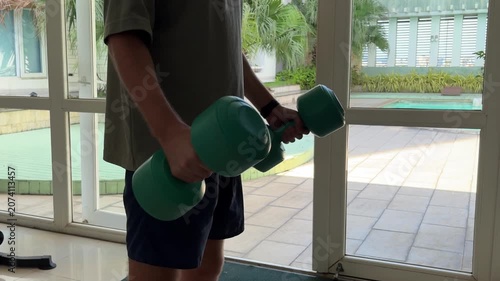 Video of a man performing dumbbell exercises in a modern gym. Fitness and strength training concept representing an active lifestyle, muscle building and personal health.