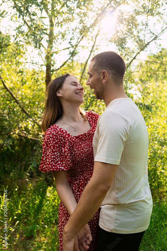 Fototapeta premium Young couple in love sharing a tender moment outdoors during a sunny day