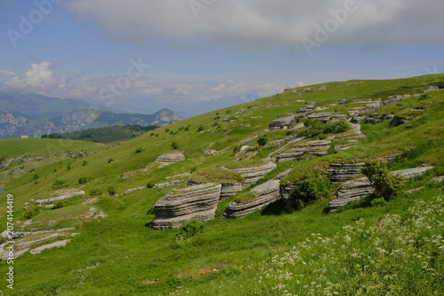 Mountain landscape in Malga Lessinia with limestone rocks and green hills