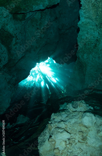 Obraz na płótnie Ambient sunlight entering a limestone cenote cave through small openings above