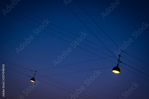 Street Lamps Hanging on Wires Against Deep Blue Twilight Sky