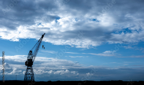 Industrial Crane Silhouette Against Dramatic Cloudy Sky