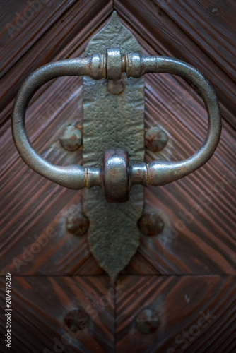 Antique wrought iron ring door knocker on wooden door