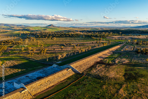 Foto Aerial scene showcasing the Lake Keepit dam wall leading into the surrounding rural landscape, highlighting the expansive reservoir, engineering infrastructure and natural beauty in NSW, Australia