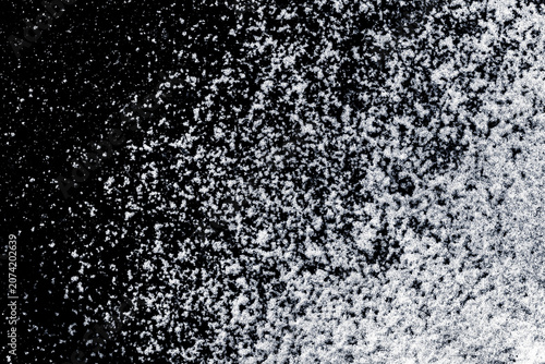 Snow, scattered on a black ice background.