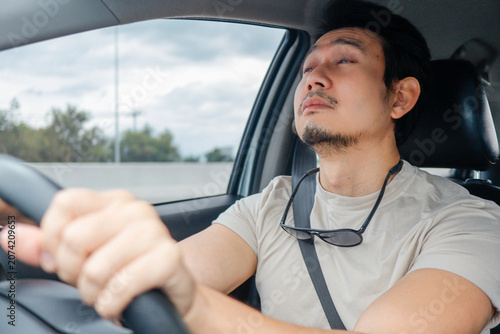 Vászonkép Tired Asian man feeling sleepy and exhausted while driving his car, battling fatigue on the road
