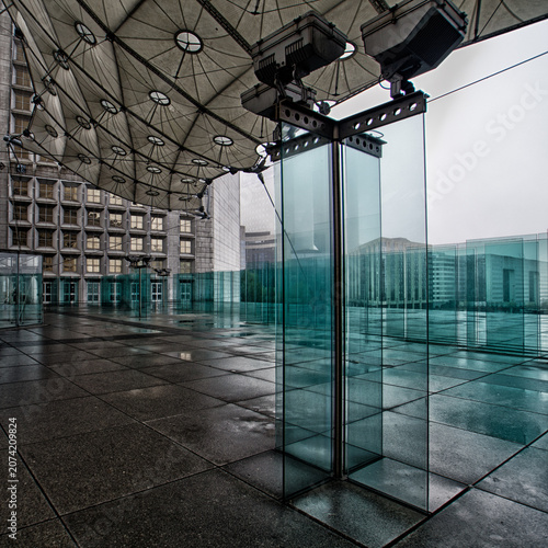 Modern glass pavilion beneath a futuristic canopy at La Défense, Paris