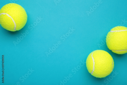 Bright yellow tennis balls on blue background. Space for text