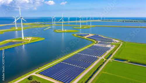 Aerial view of wind turbines and solar panel arrays on water with turbines renewable sustainabilit