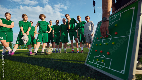 Konstfotografi Girls soccer team listening to coach tactics on outdoor field