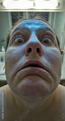 close-up of shocked person looking into phone