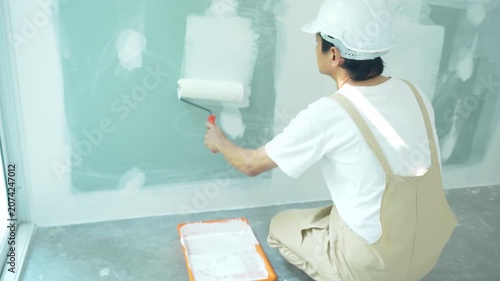 painter man, brush in hand for products to restore and paint the wall, indoor the building site of a house, wall during painting, renovation, painting, contractor, Architect, construction worker