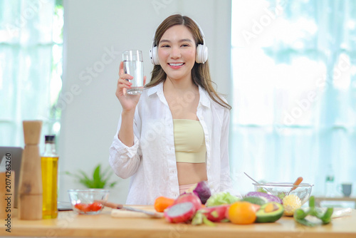 Canvastavla Asian women in good spirits hold glass clean water drink while cooking refresh themselves and ensure have enough water which helps keep bodies refreshed energetic beneficial their health