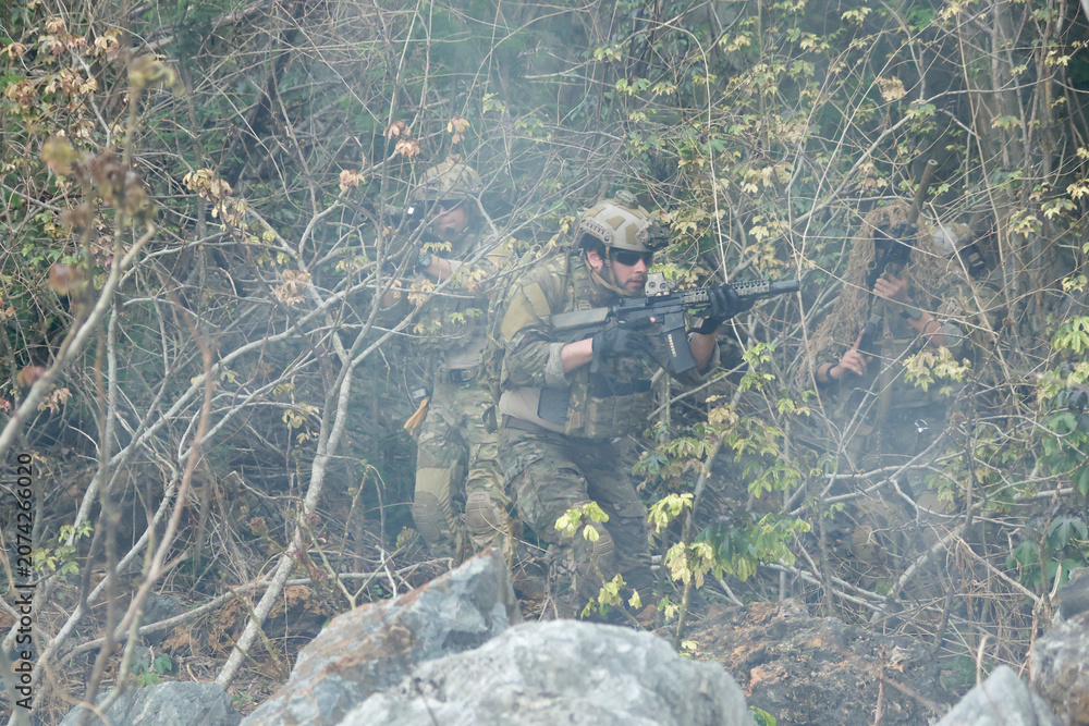 Fototapeta premium Soldiers group together to perform their duties in wartime soldiers in camouflage uniforms carrying weapons conduct patrols through dangerous mountainous forest areas.