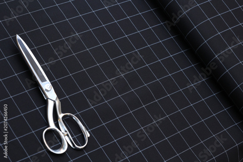 Fotografija Premium cotton suiting fabric featuring a clean grid windowpane pattern in black and white lines and scissors atop