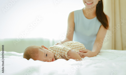 Obraz na plátně Heartwarming moment depicting the love and bond between mother and her eight month old son on a comfortable bed the young mother lovingly caresses her baby and the warmth family