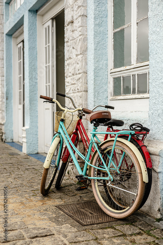 Bicicletas azul e vermelha encostadas na parede em cidade histórica de São Francisco do Sul