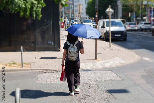 Foto Person using an umbrella for shade while walking during an extreme summer heat w