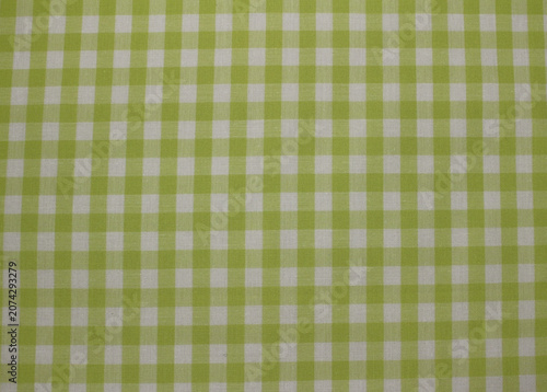 Texture of classic lime green and white gingham cotton cloth background. Close up of green plaid fabric. 