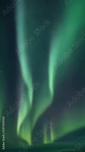 Vibrant green aurora borealis shimmering in the night sky.
Time-lapse of vibrant green northern lights waving across a dark night sky.