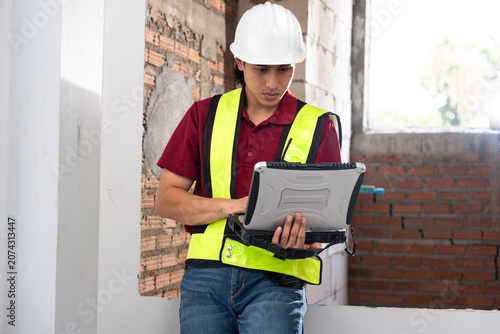 Construction worker using laptop at building site