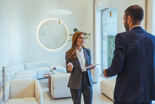 Business Professionals Conversing in Modern Office Lounge During Casual Client Meeting and Consultation