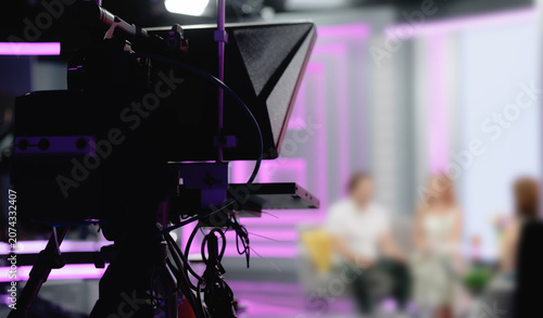 Bild auf Leinwand Television camera with teleprompter filming guests on studio set, blur backgroun