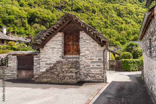 Traditional stone farmhouse with a characteristic beola stone roof located along in the historic center of Maggia, Canton of Ticino, Switzerland.