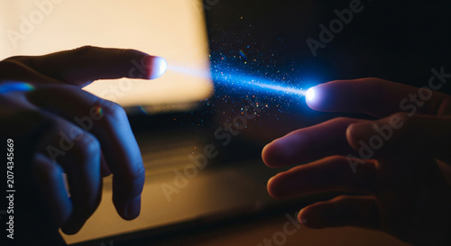 Two hands reaching towards each other with a bright light effect dark photo