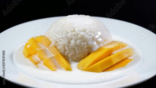 Delicious Thai Mango Sticky Rice Dessert Served with Creamy Coconut Sauce and Ripe Mango Slices on Elegant Plate