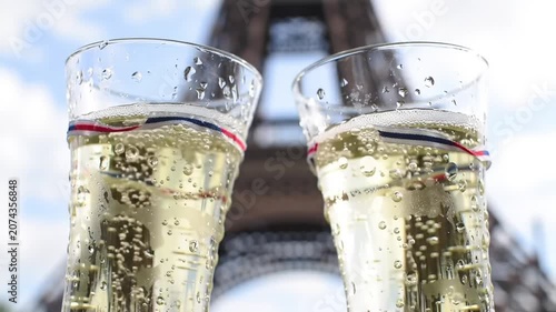Two champagne glasses with French ribbons before Eiffel Tower Paris