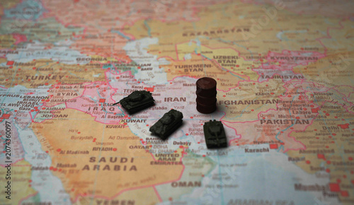 Miniature tanks and oil barrel on Iran map conflict concept.