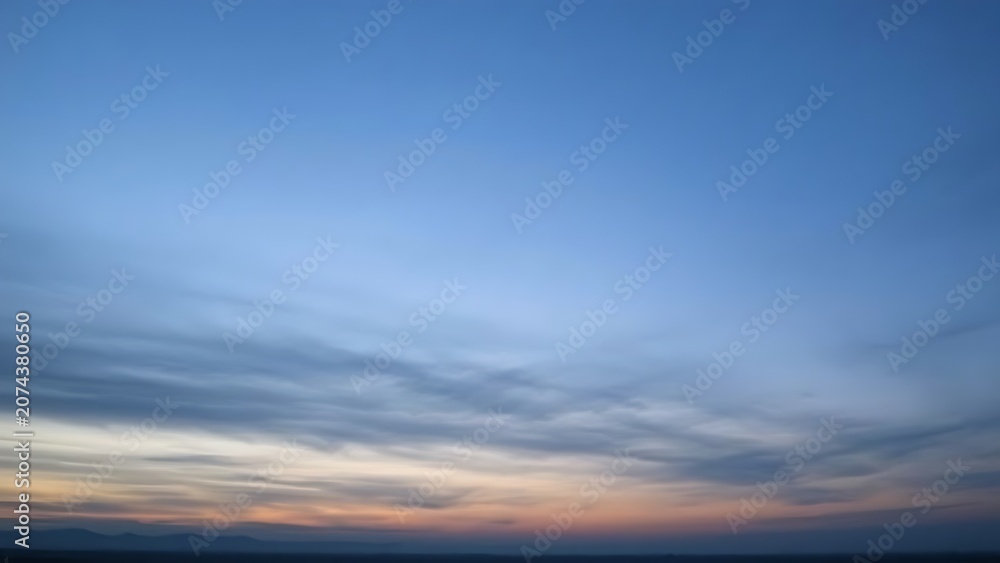 Fototapeta premium Pre-dawn sky in gray-blue tones before sunrise over distant horizon.