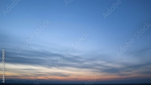 Pre-dawn sky in gray-blue tones before sunrise over distant horizon.