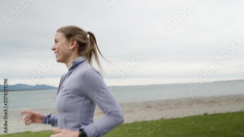 Fit young woman running along a scenic lakefront path