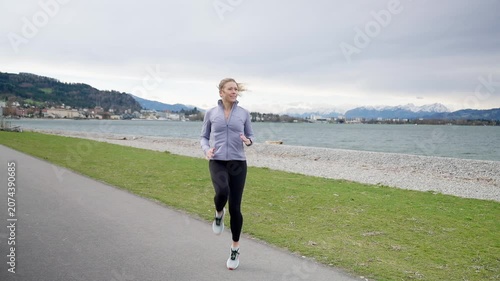 Athletic woman warming up outdoors by the lake