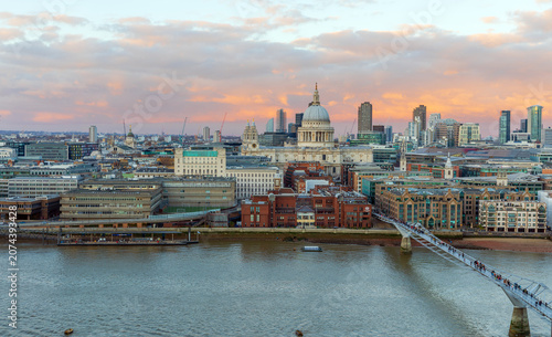 Panoramic view of London skyline with St. Paul's Cathedral and Millennium Bridge at sunset