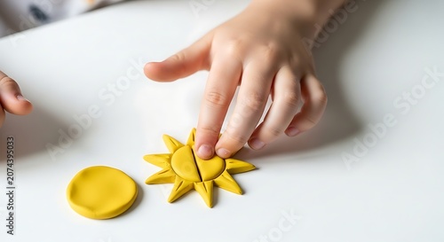 Small child playing with bright yellow clay sun shapes indoors