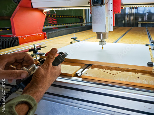 Close-up of a worker calibration process and setting zero point on a CNC router