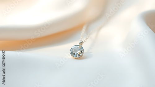 Delicate gemstone pendant on silk fabric, fine jewelry elegance.